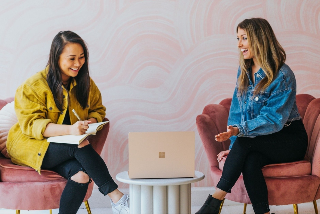 Zwei Frauen mit Personalmanagement Studium glücklich im Beruf.