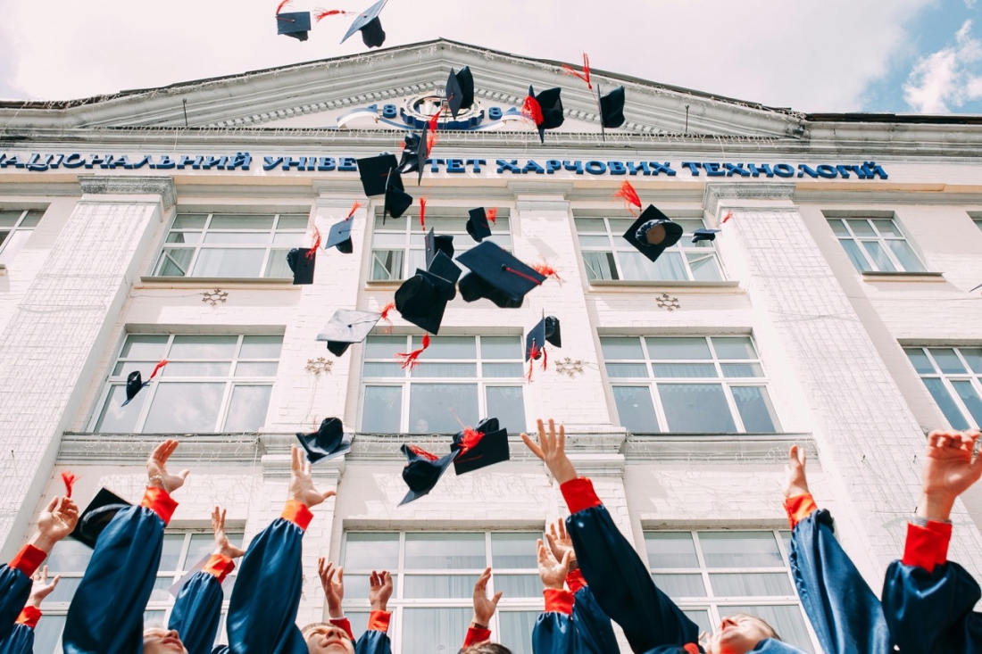 Absolventen werfen ihre Hüte in die Luft - Ratgeber Campus M University Kosten.