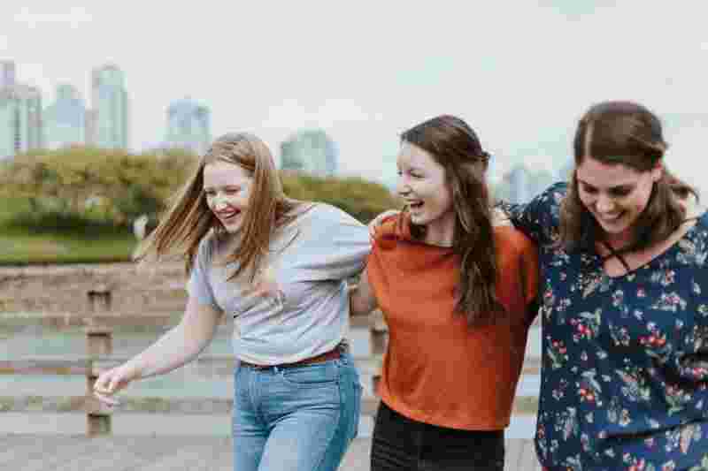 Drei lachende junge Frauen umarmen sich - Ratgeber Sportpsychologie Studium Campus M University
