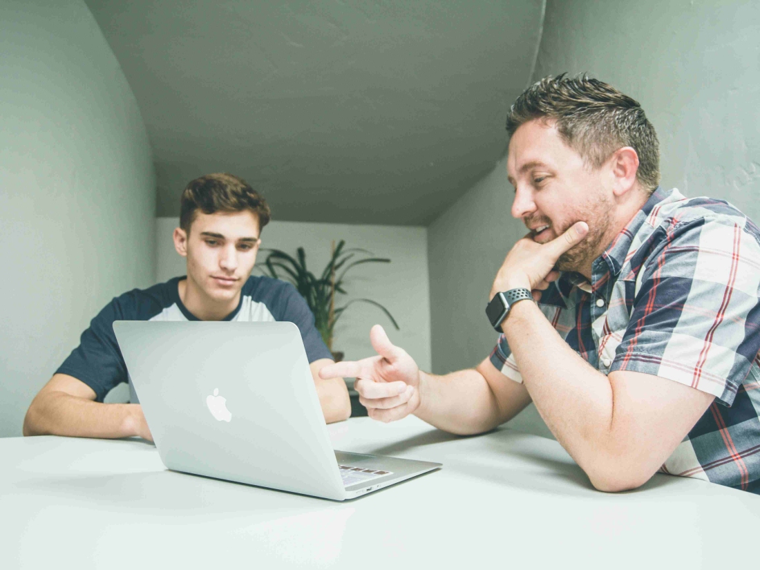 Ein persönlicher Coach unterstützt einen Studierenden beim Verständnis der Wirtschaftspsychologie Studieninhalte.