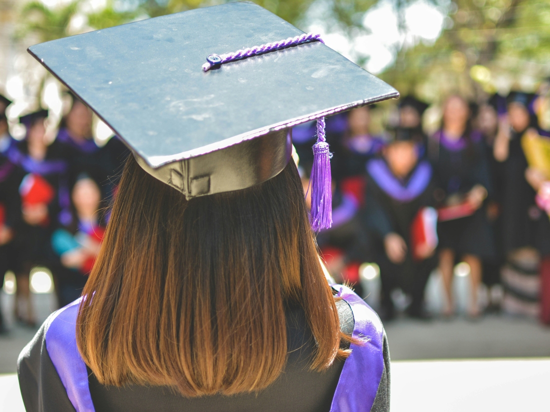 Hochschulabsolventin bei der Absolventenfeier von hinten - Ratgeber Social Media Studium: Campus M University.