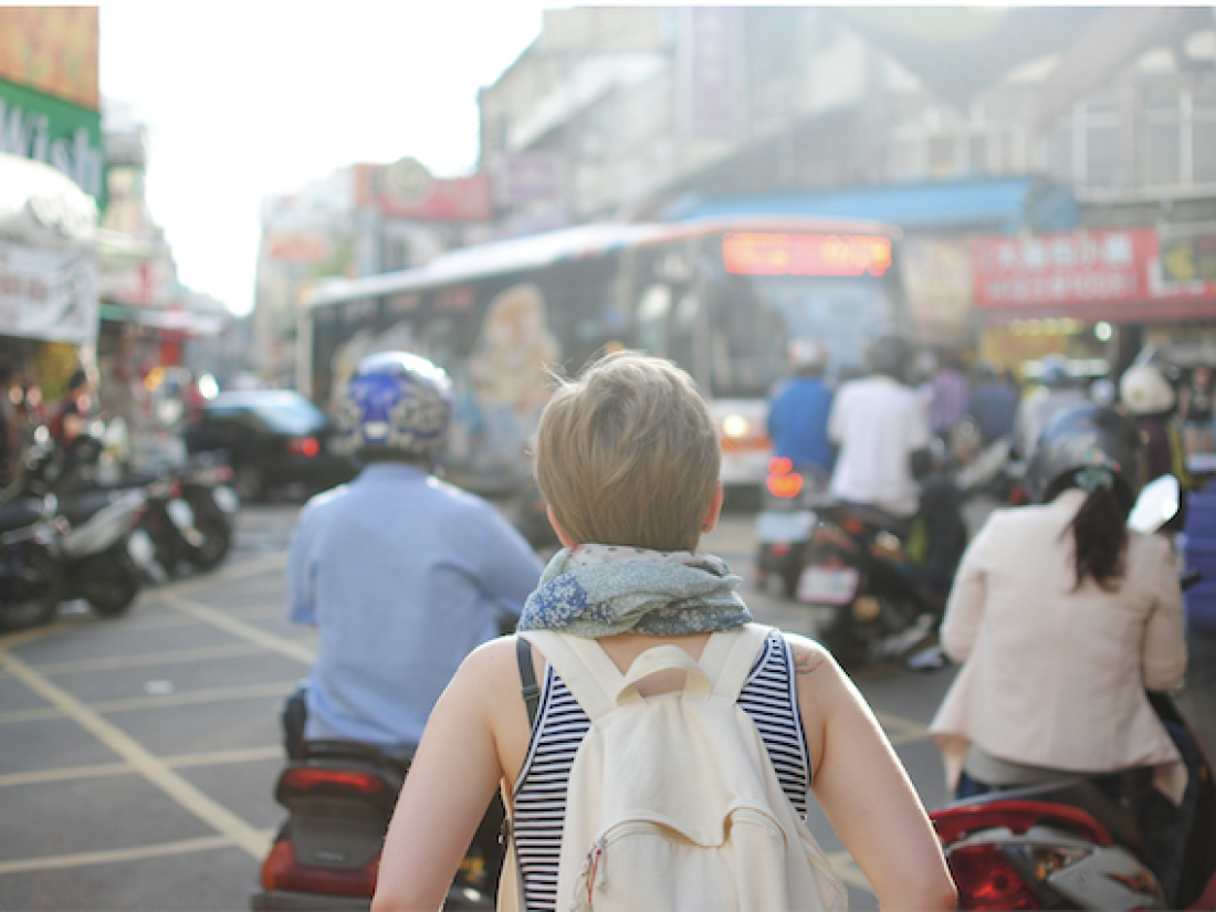 Junge Frau mit Rucksack von hinten - Ratgeber Studium im Tourismus: Campus M University.