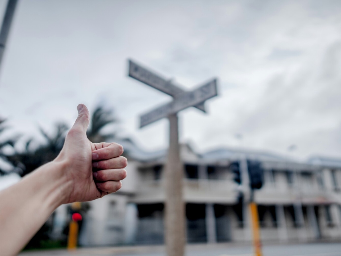 Hand mit Daumen nach oben vor einem Wegweise - Ratgeber Studium im Tourismus: Campus M University.