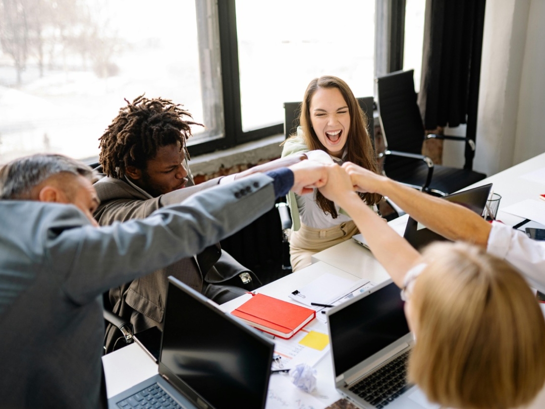 Glückliche Studentengruppe, Fistbump mit Professor - Ratgeber Brand Management Studium: Campus M University.