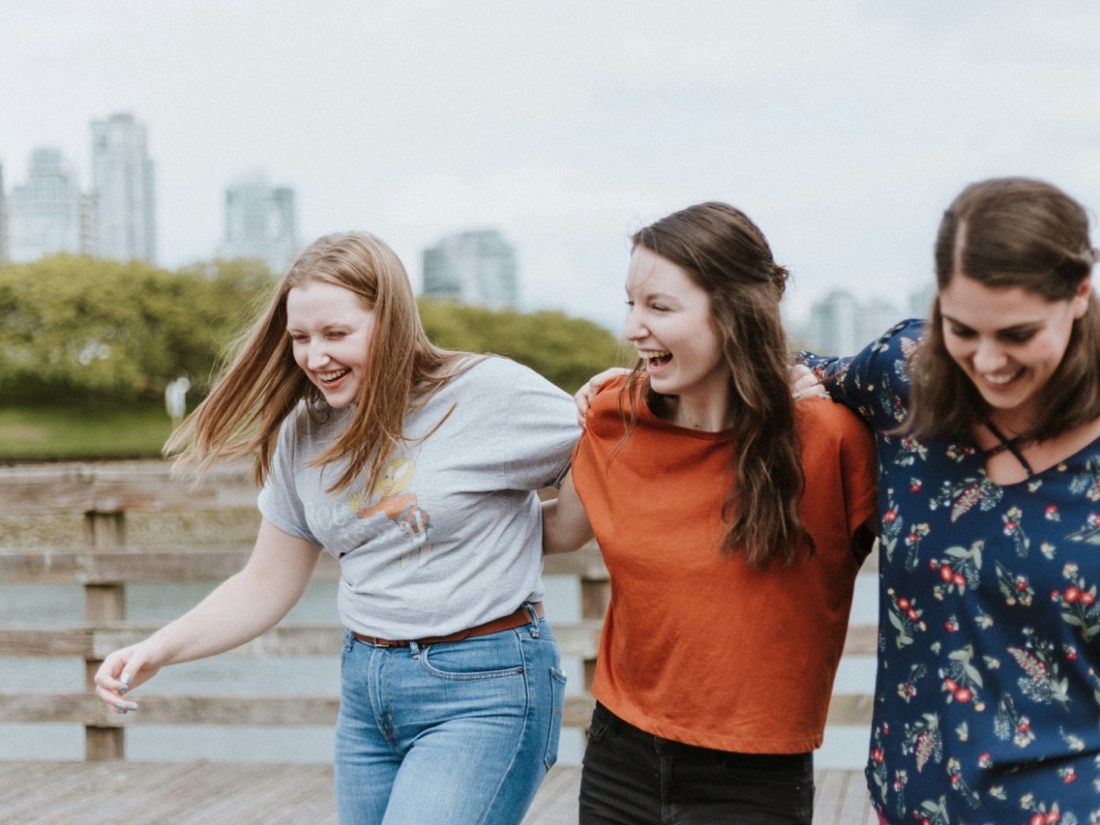 Drei lachende junge Frauen umarmen sich - Ratgeber Sportpsychologie Studium Campus M University