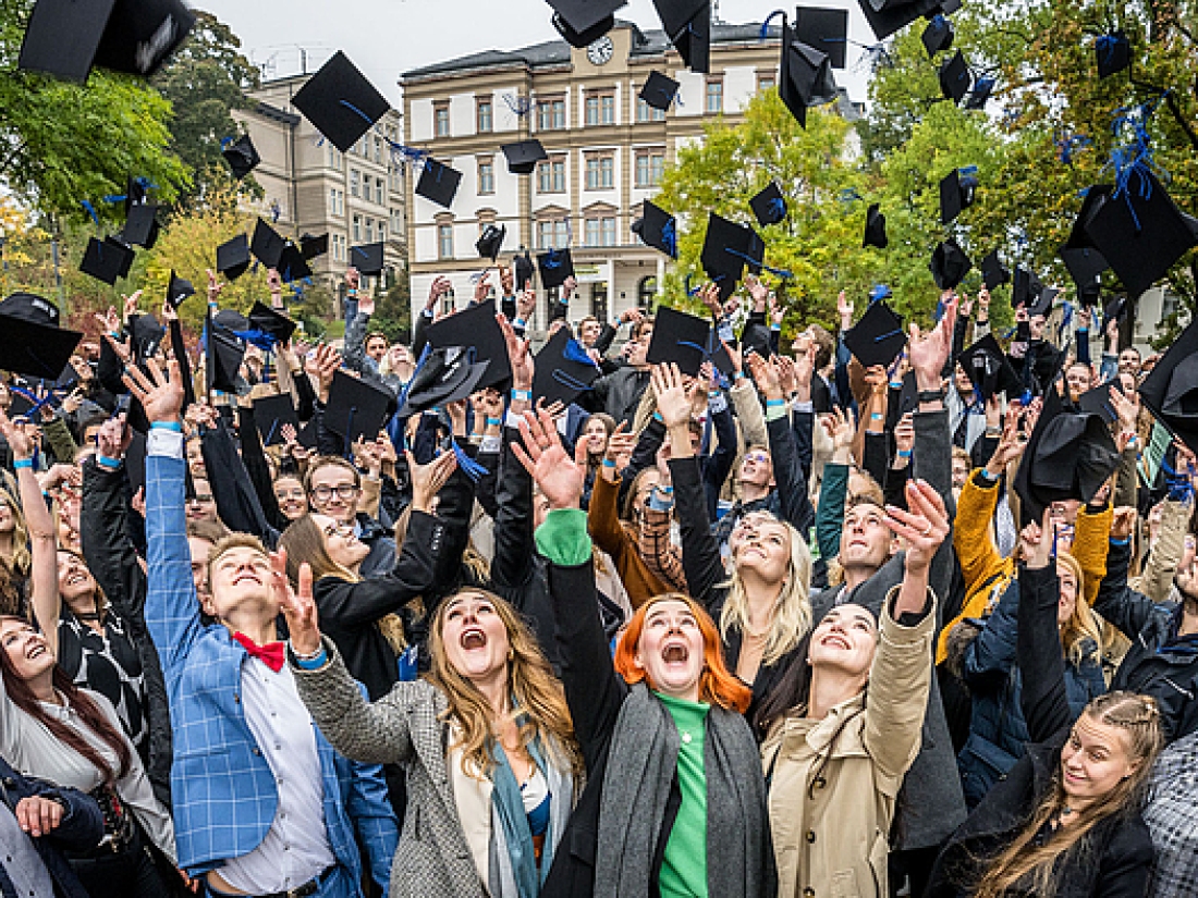 Jubelnde Studierende bei Ihrem Abschluss werfen Hüte in die Luft - Ratgeber Studium im Tourismus: Campus M University.